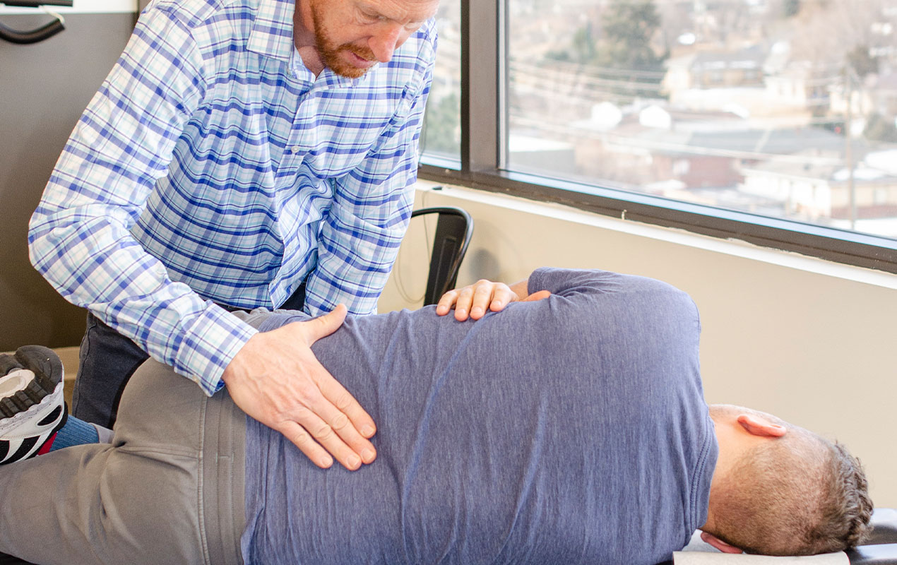 Dr. John Steffens works with a patient to resolve lower back pain issues.